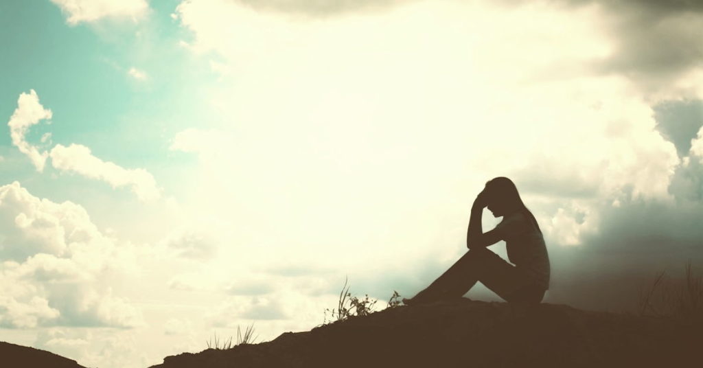 Woman Seated Holding her Head in Her Hand