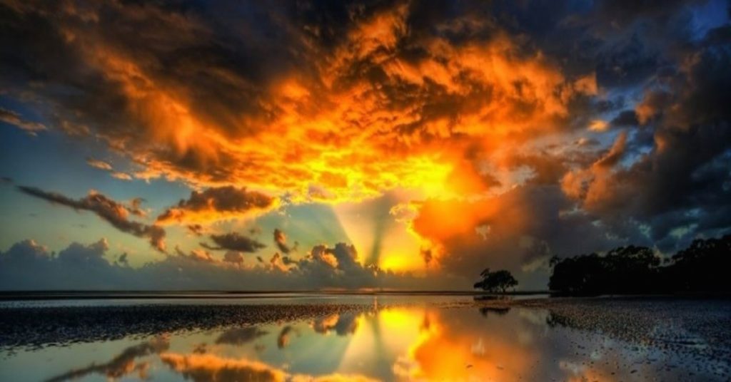 Golden Sun and Orange Clouds Reflecting on the Water