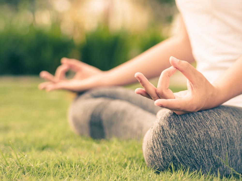 Person Meditating on Grass, Using Mudras