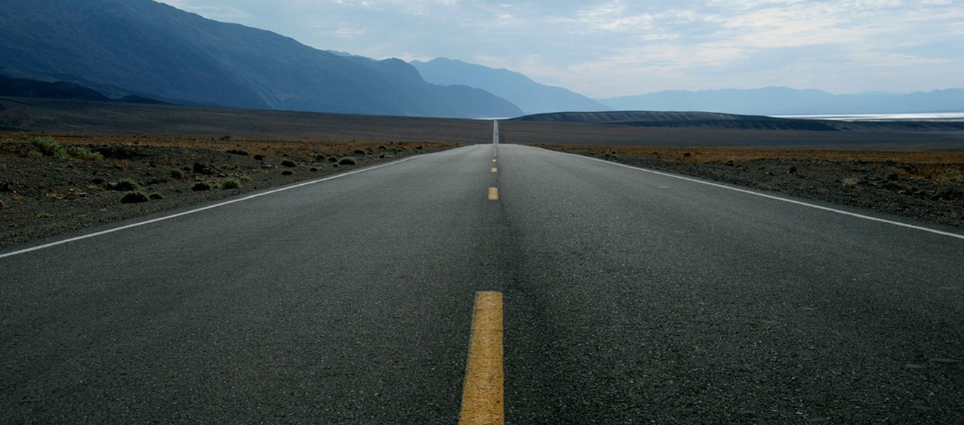 Open Road Leading Into Mountains and Horizon