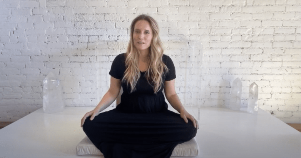 Seated Woman Meditating in Front of Large Crystals