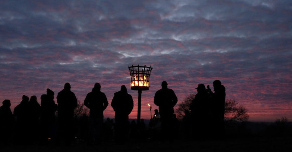 People Gathered Around Torches After Sunset