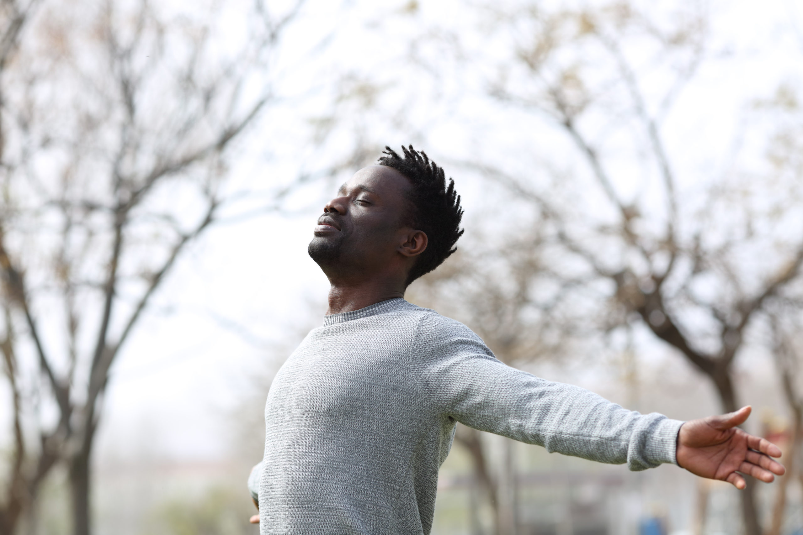 Man Standing with Eyes Closes and Arms Outreached