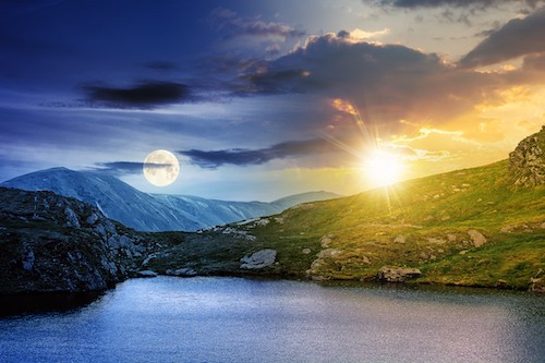 day and night change above the landscape with lake day and night time change concept above summer landscape with lake on high altitude. beautiful scenery of fagaras mountain ridge. open view in to the distant peak beneath a clouds with sun and moon
